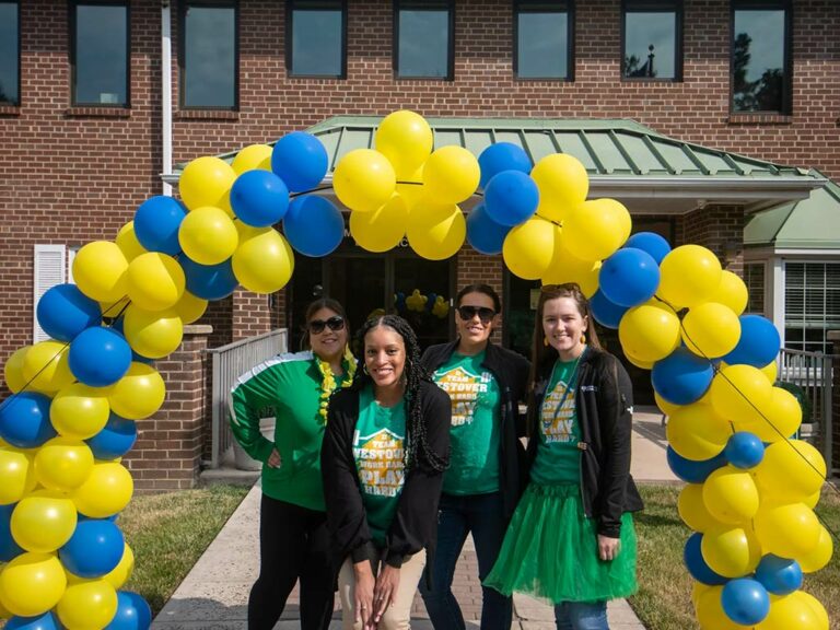 Volunteers standing under a balloon trellis