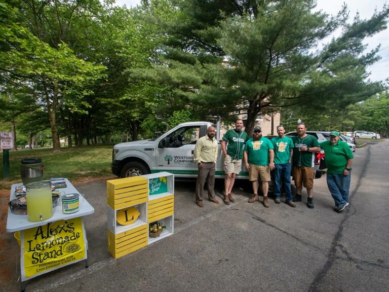 Volunteers standing near a truck and lemonade stand
